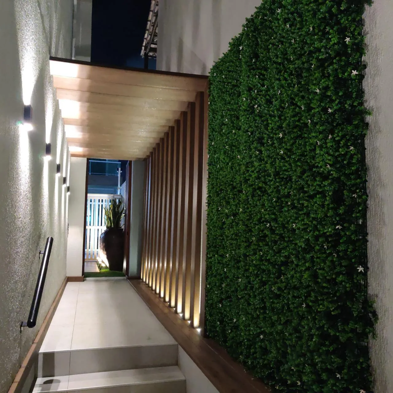 Corredor externo concluído com deck, pergolado e jardim vertical