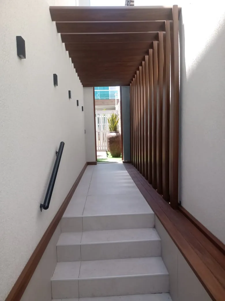Passagem lateral revestida com perfis amadeirados