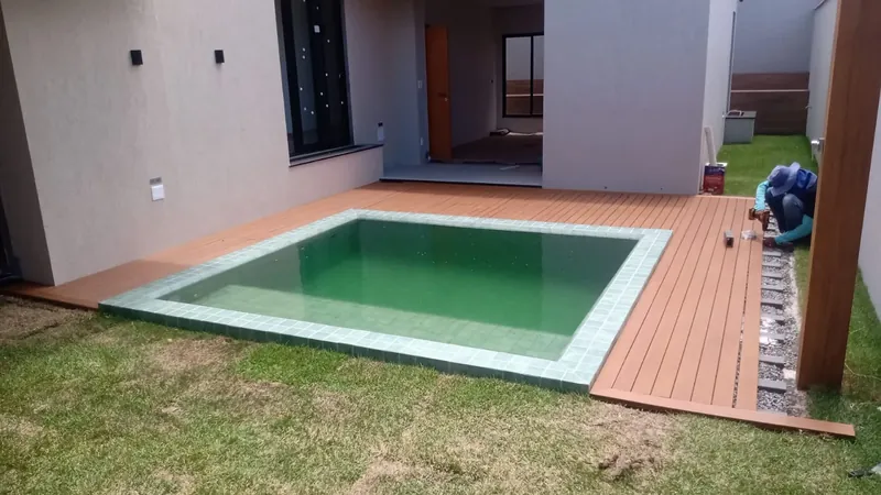 Área residencial com deck em madeira plástica concluído no entorno da piscina